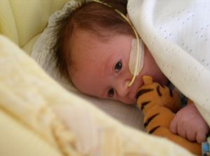 Samuel, wrapped in a blanket, holding his Tigger toy